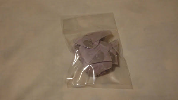 something wrapped in branded tissue paper in a sealed plastic pouch